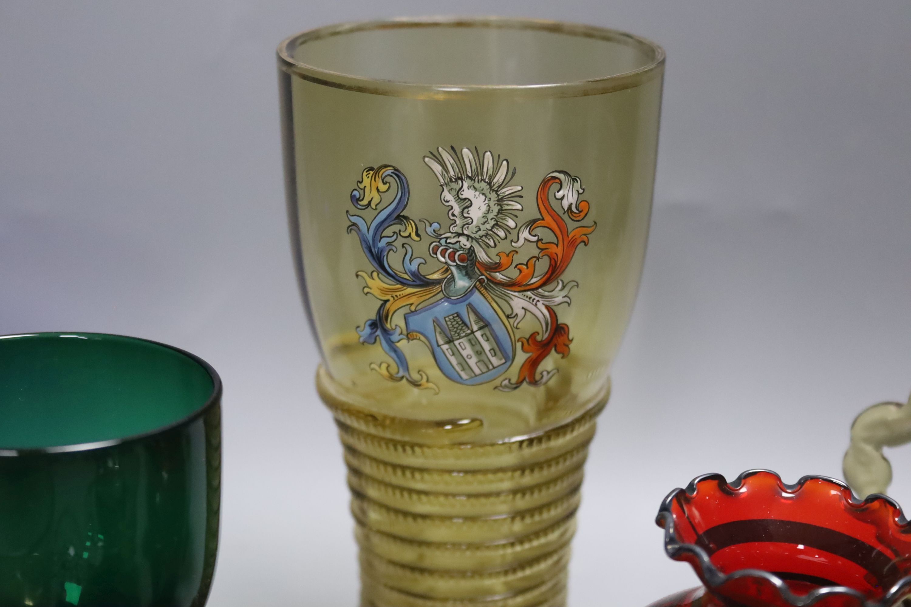 A German glass beaker with enamelled crest, 17.5cm, four Roemers, a millefiori paperweight and coloured glassware
